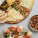 an assorted food on a charcuterie board and ceramic plate