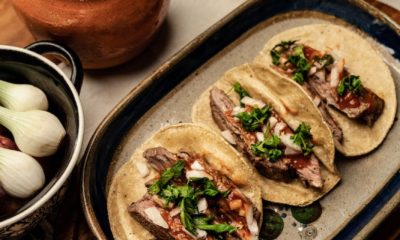 sliced beef steak and green vegetable on top of tortilla