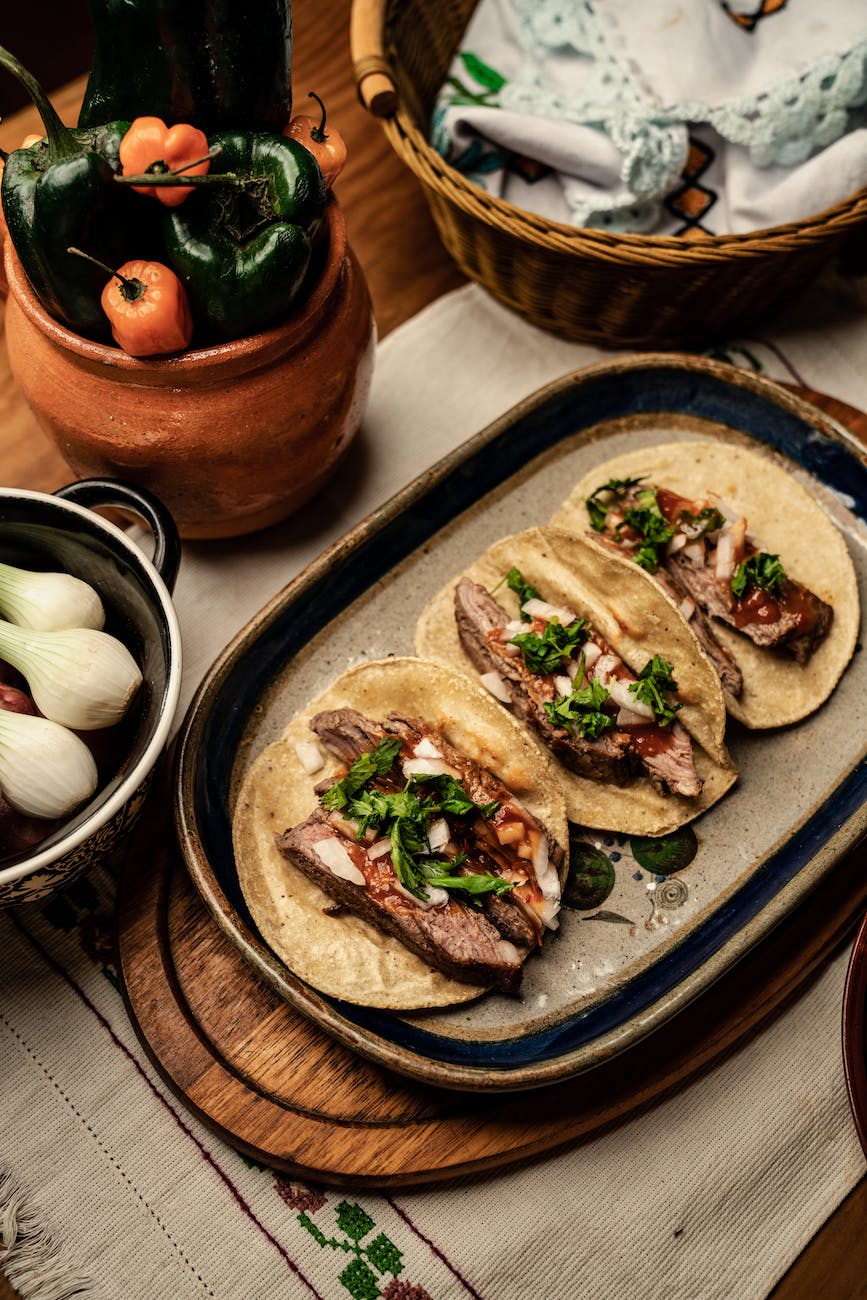 sliced beef steak and green vegetable on top of tortilla